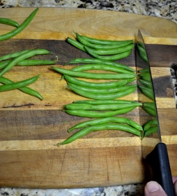 First push the beans against the knife blade.